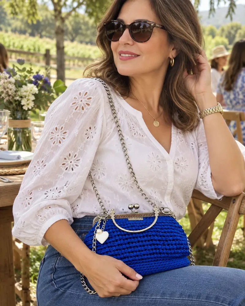 Clutch Azul Rey: Bolso de mano tejido a crochet en azul rey con boquilla metálica plateada, cadena desmontable y dije de corazón